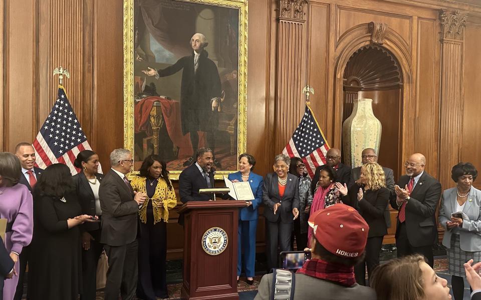 Members of CBC standing with Rep. McClellan as she's sworn into the Caucus