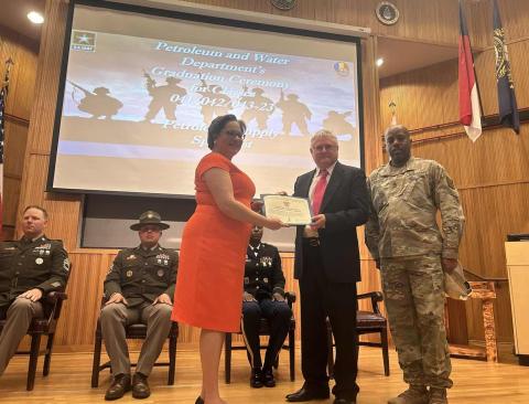 Rep. McClellan stands on stage at Fort Gregg-Adams to recieve an award