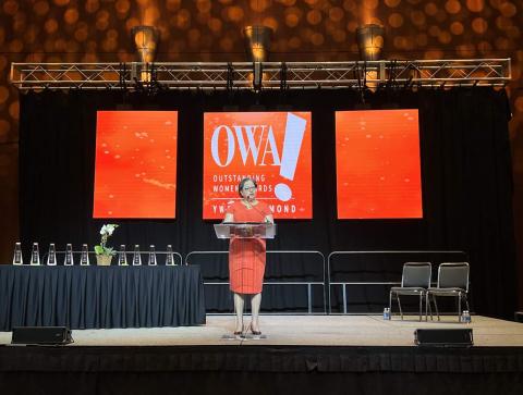 Rep. McClellan stands on stage at the YWCA's Outstanding Women Awards