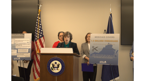 Photo of Aida Pacheco speaking at a podium.