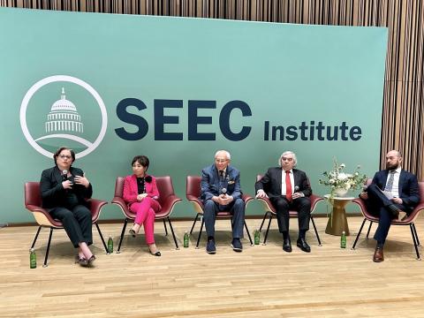 McClellan sits on stage with other SEEC leaders for a Member panel.