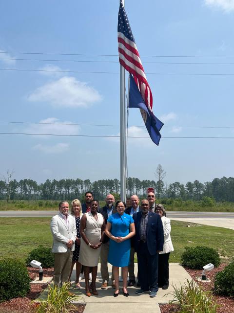 Rep. McClellan stands with Sussex, Surry, and Southampton leaderhip in front of a flag pole